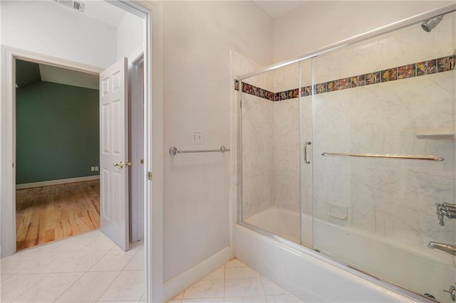 bathroom with enclosed tub / shower combo and baseboards