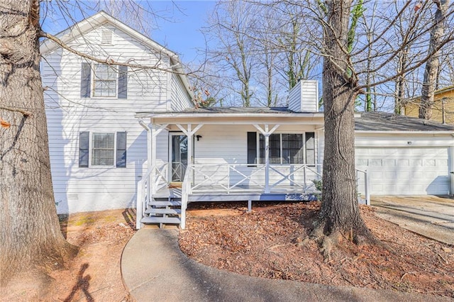 view of front of house featuring a garage, covered porch, a chimney, and concrete driveway