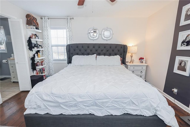 bedroom featuring wood finished floors, a ceiling fan, and baseboards