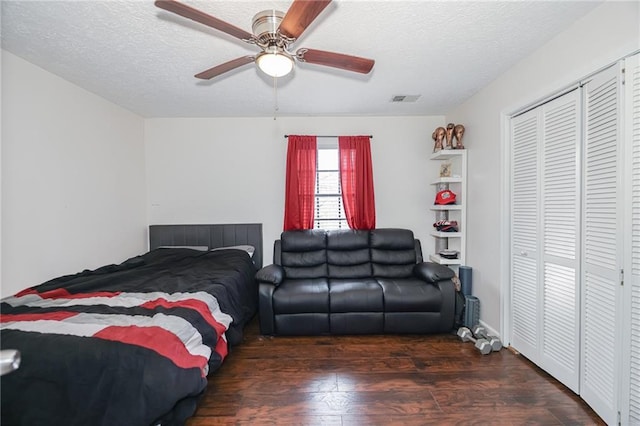 bedroom featuring a closet, visible vents, a ceiling fan, a textured ceiling, and wood finished floors