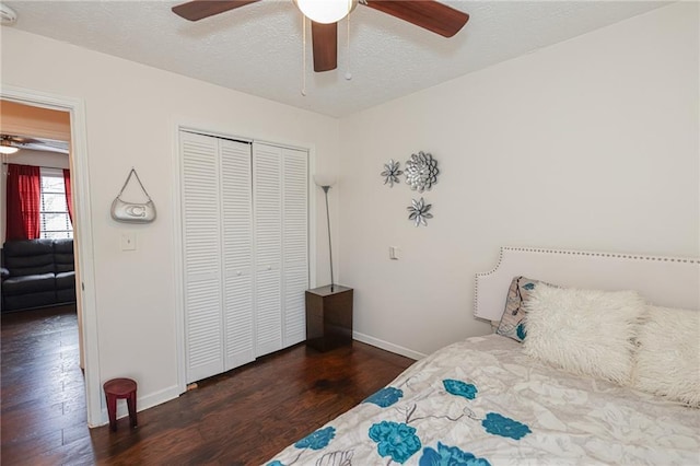 bedroom with a closet, ceiling fan, a textured ceiling, wood finished floors, and baseboards