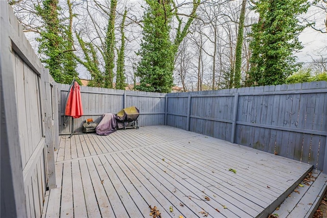 wooden terrace with a fenced backyard