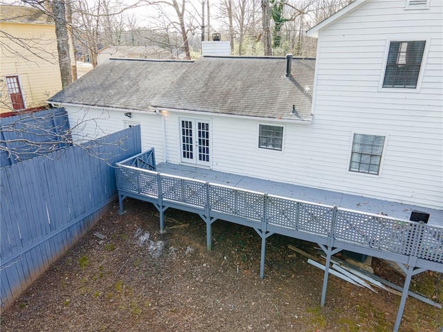 back of house with french doors, roof with shingles, a chimney, and a wooden deck