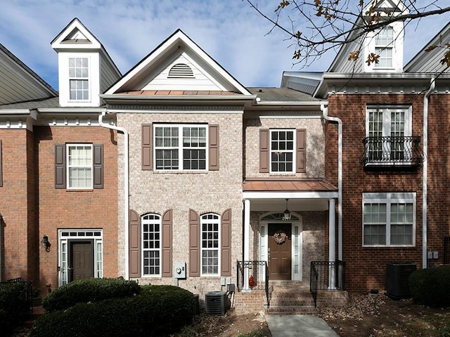 view of property featuring central AC and brick siding