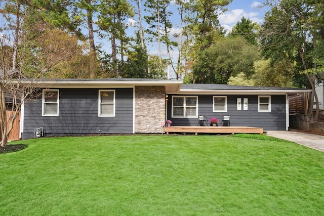 back of property featuring a deck and a lawn