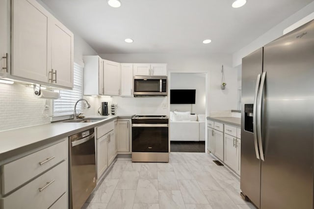 kitchen featuring white cabinetry, stainless steel appliances, sink, and tasteful backsplash