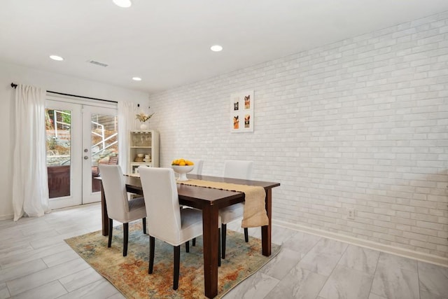 dining space with brick wall and french doors