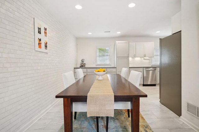 dining room with brick wall