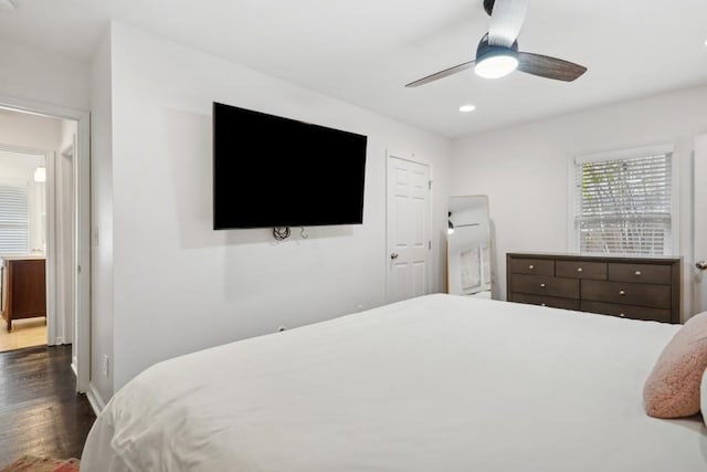 bedroom with dark hardwood / wood-style floors and ceiling fan