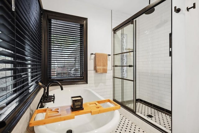 bathroom with a shower with shower door and tile patterned flooring