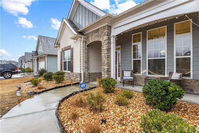 view of exterior entry with a garage and a porch