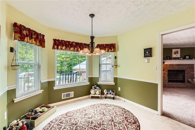 180 Moseley Crossing Dr, Stockbridge, GA 30281 - carpeted dining area with a chandelier, a textured ceiling, a fireplace, and tile patterned floors
