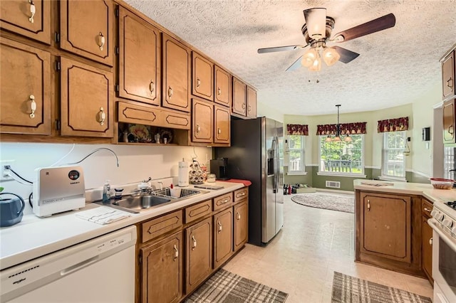 180 Moseley Crossing Dr, Stockbridge, GA 30281 - kitchen featuring white appliances, brown cabinetry, a ceiling fan, light countertops, and a textured ceiling