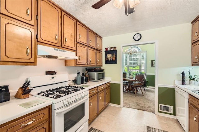 180 Moseley Crossing Dr, Stockbridge, GA 30281 - kitchen with white appliances, under cabinet range hood, brown cabinetry, light countertops, and a textured ceiling