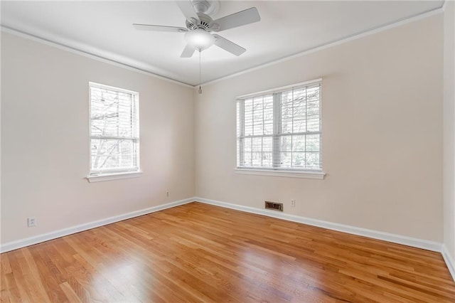 unfurnished room featuring light wood-type flooring, visible vents, baseboards, and ornamental molding