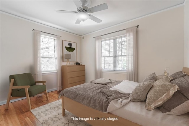 bedroom featuring ceiling fan, crown molding, and light wood-style floors