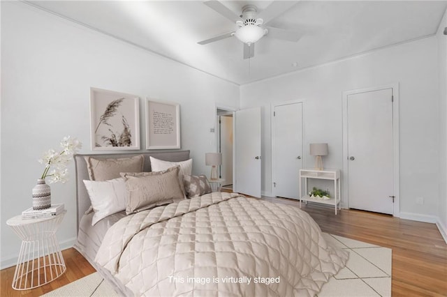 bedroom with a ceiling fan, wood finished floors, and baseboards