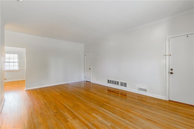 unfurnished room with visible vents, light wood-style floors, and crown molding