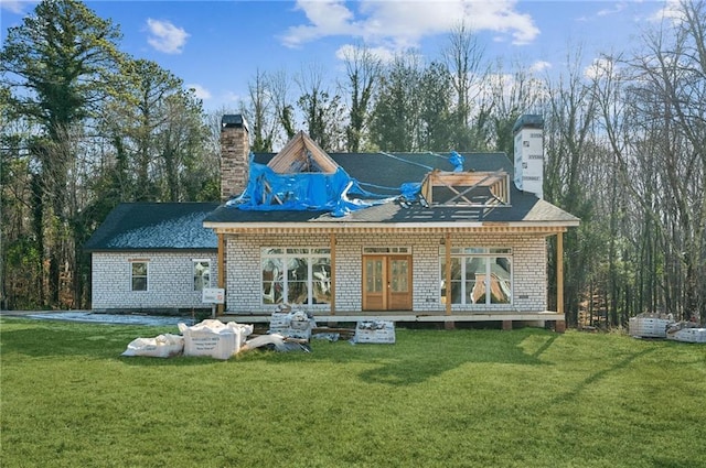 back of house featuring a yard and french doors