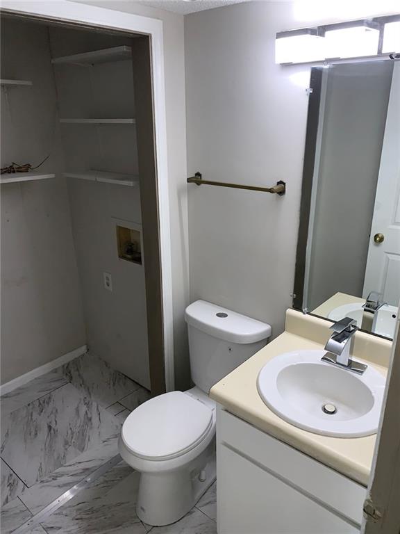 4347 Barrington Pl, Macon, GA 31210 - half bathroom featuring marble finish flooring, vanity, and toilet