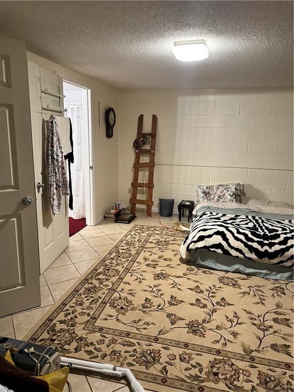 tiled bedroom with a textured ceiling