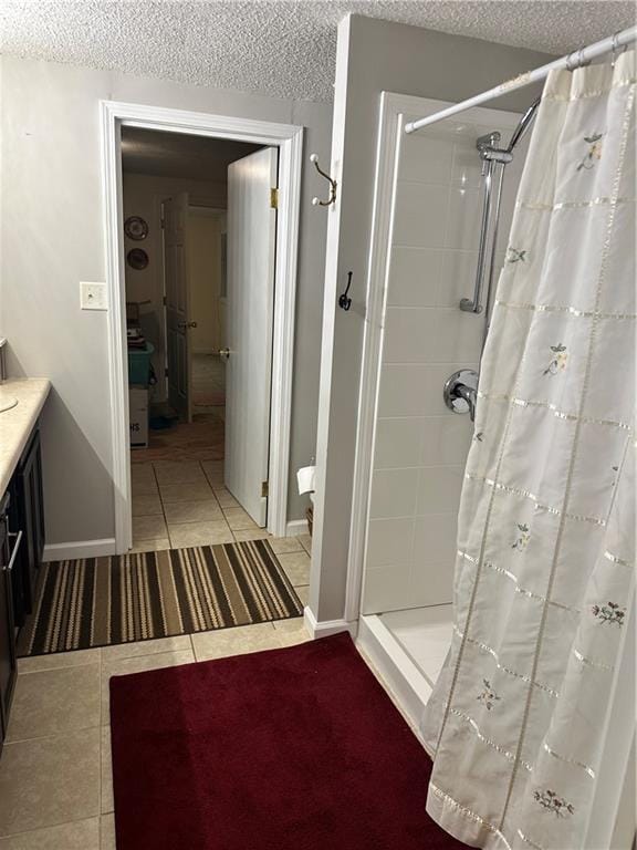 bathroom with curtained shower, tile patterned floors, a textured ceiling, and vanity