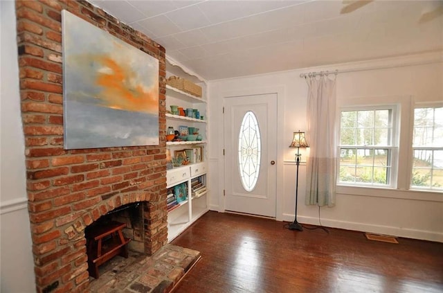 entryway with dark wood-type flooring and a fireplace