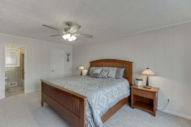 bedroom with light carpet, ceiling fan, a textured ceiling, and ensuite bathroom