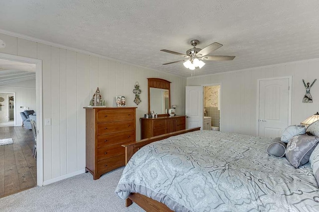 bedroom with connected bathroom, ceiling fan, crown molding, light carpet, and a textured ceiling