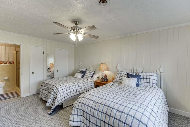 carpeted bedroom featuring crown molding, ceiling fan, and a textured ceiling