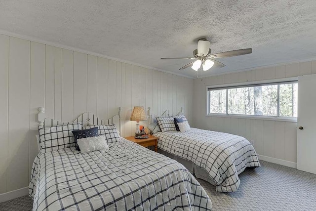 bedroom with ceiling fan, carpet floors, and a textured ceiling