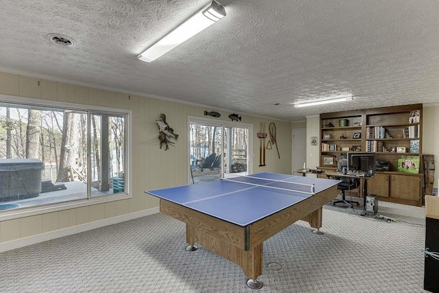 recreation room featuring ornamental molding, a wealth of natural light, and light colored carpet