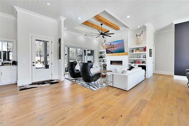 1455 Rucker Cir, Woodstock, GA 30188 - living area featuring light wood-type flooring, a glass covered fireplace, recessed lighting, a ceiling fan, and crown molding