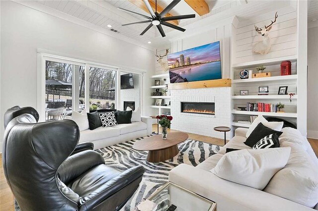 1455 Rucker Cir, Woodstock, GA 30188 - living room featuring a ceiling fan, wood finished floors, a glass covered fireplace, beamed ceiling, and visible vents