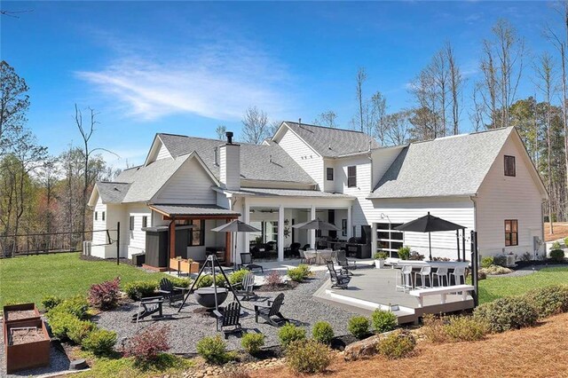 1455 Rucker Cir, Woodstock, GA 30188 - rear view of property featuring roof with shingles, a chimney, fence, a patio area, and a yard
