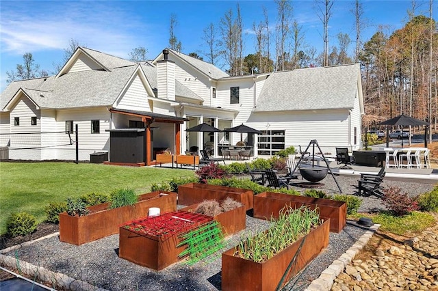 1455 Rucker Cir, Woodstock, GA 30188 - back of house with a lawn, a shingled roof, a garden, and a patio area