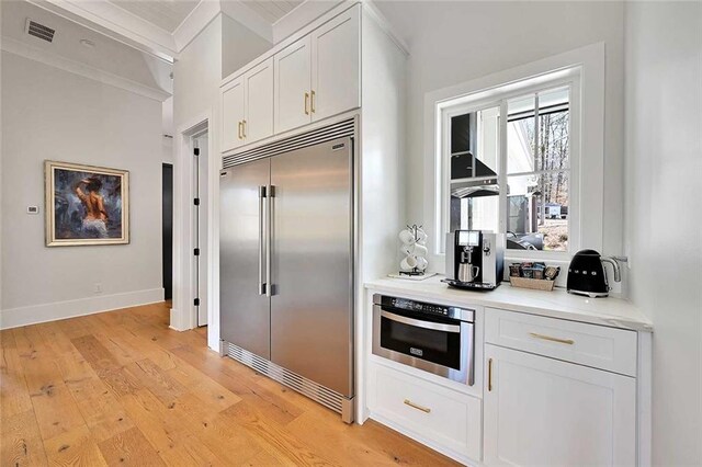 1455 Rucker Cir, Woodstock, GA 30188 - kitchen featuring built in fridge, light wood-style flooring, white cabinetry, visible vents, and wall oven