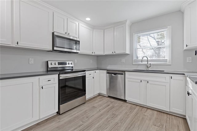 1974 Browns Mill Rd SE, Atlanta, GA 30315 - kitchen featuring stainless steel appliances, a sink, light wood-style floors, white cabinets, and recessed lighting
