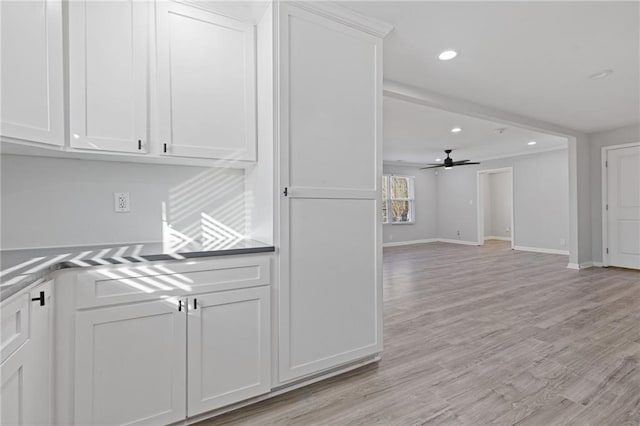 kitchen with white cabinets, ceiling fan, and light hardwood / wood-style flooring