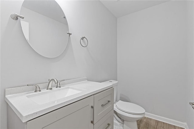 bathroom with vanity, wood-type flooring, and toilet