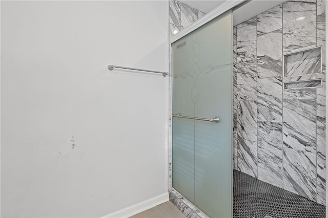 bathroom featuring a shower with shower door