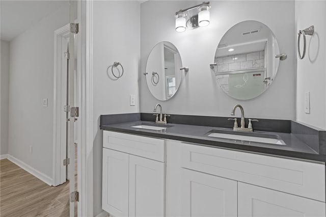 1974 Browns Mill Rd SE, Atlanta, GA 30315 - bathroom featuring double vanity, wood finished floors, and baseboards