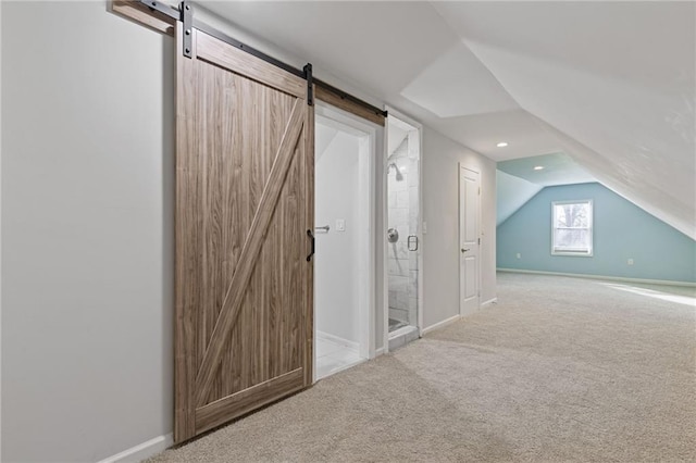 additional living space featuring lofted ceiling, a barn door, and carpet flooring