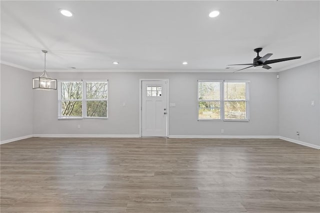 unfurnished living room featuring crown molding, ceiling fan, and light hardwood / wood-style flooring