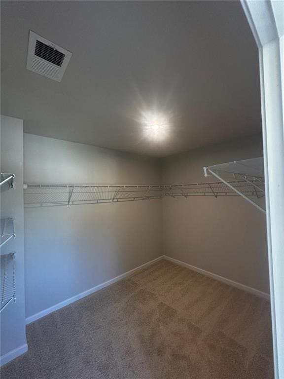 walk in closet with carpet flooring and arched walkways