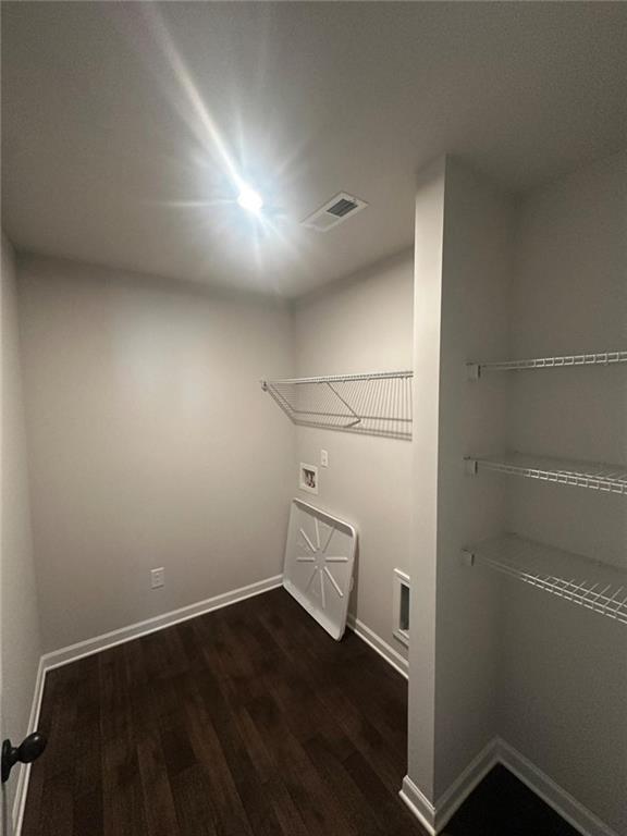 washroom featuring washer hookup, dark wood-style flooring, and baseboards