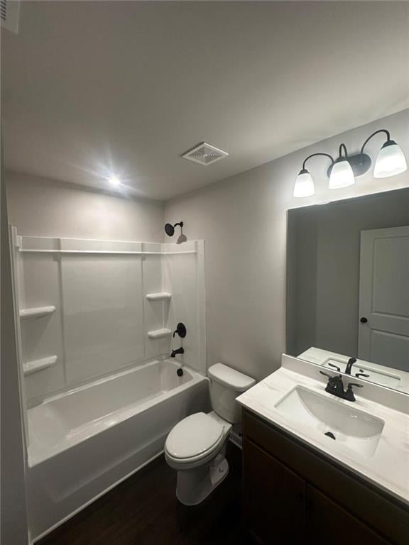bathroom with bathing tub / shower combination, toilet, vanity, and wood finished floors