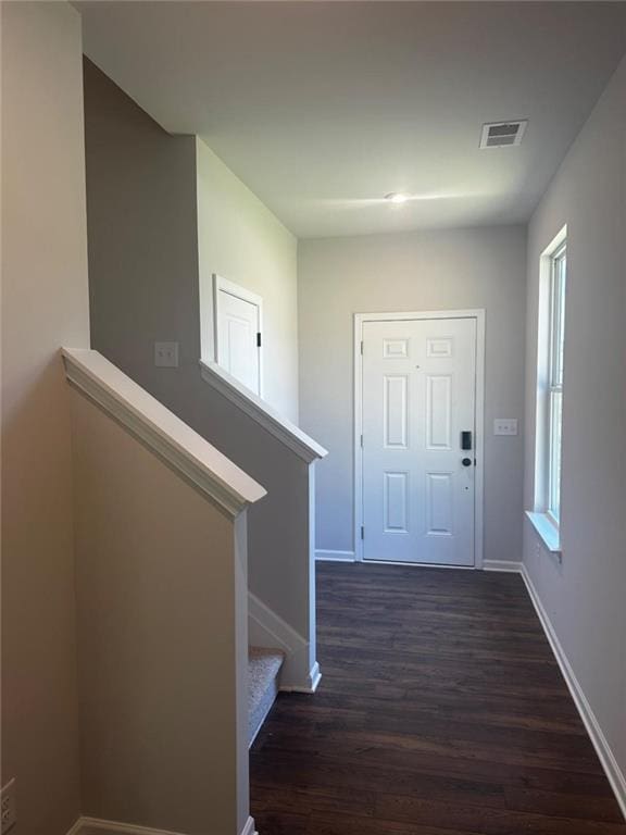entryway featuring dark wood-style floors, baseboards, and stairs