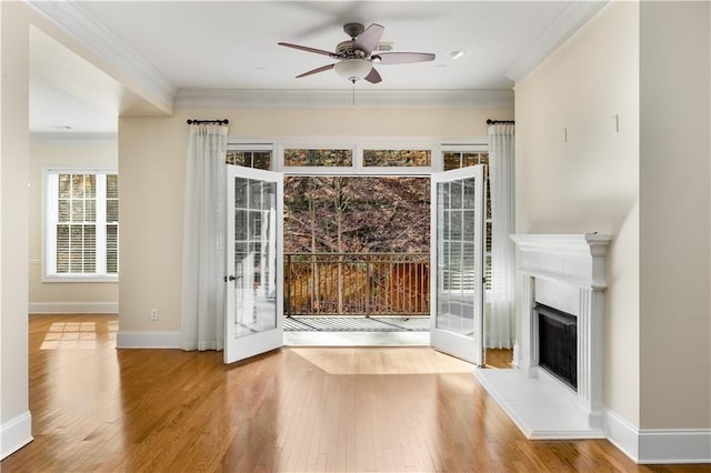 entryway with wood-type flooring, ornamental molding, and ceiling fan