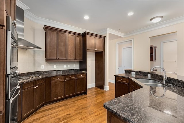 kitchen with sink, light hardwood / wood-style flooring, tasteful backsplash, ornamental molding, and dark stone counters